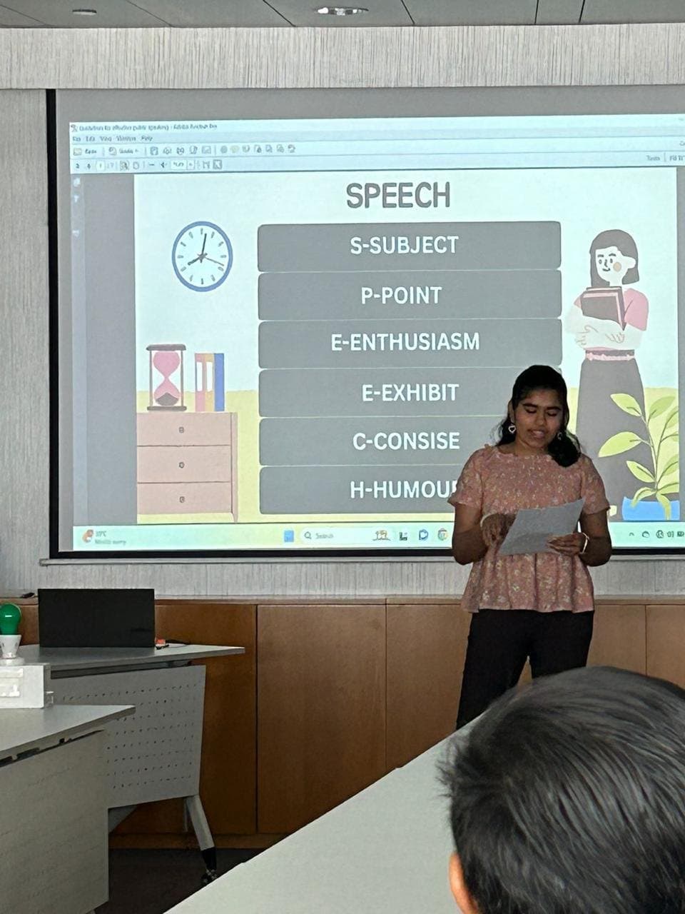 A member delivering a prepared speech in front of a presentation slide